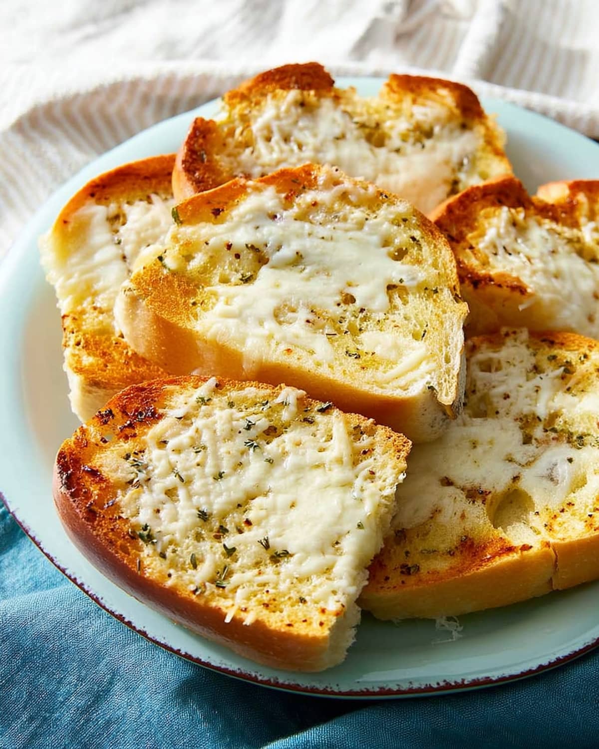 Torrada de alho na Airfryer dourada e crocante, coberta com queijo derretido e ervas perfumadas.